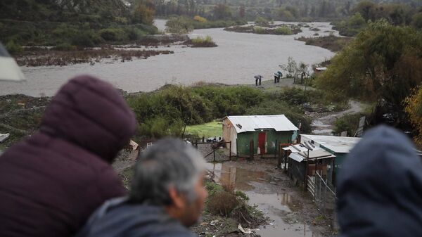 Habitantes miran el río Mapocho tras las fuertes lluvias en la comuna de Talagante, Santiago, el 13 de junio de 2024.  - Sputnik Mundo