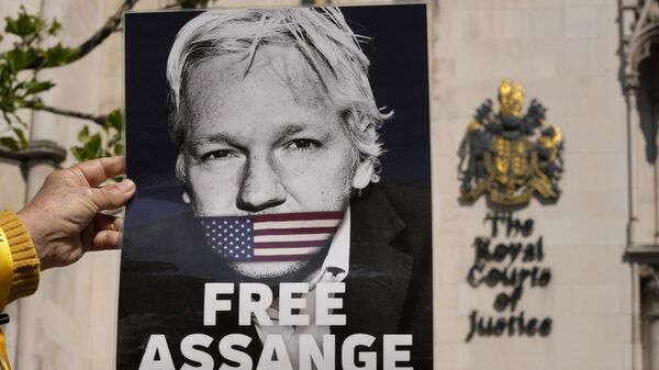 Un manifestante sostiene un cartel del fundador de WikiLeaks, Julian Assange, frente al Tribunal Superior de Londres, el 20 de mayo de 2024  - Sputnik Mundo