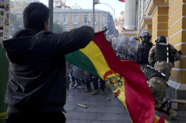 Un partidario del mandatario actual del país agita la bandera boliviana mientras los soldados huyen de la plaza principal de La Paz, después de un fallido intento de golpe de Estado militar. - Sputnik Mundo