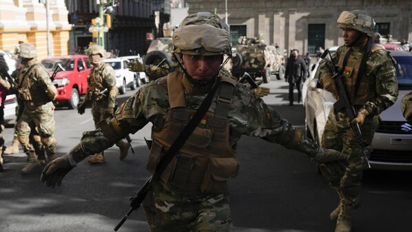 Un soldado hace un gesto a los periodistas para que abandonen la Plaza Murillo mientras los militares se reúnen frente al palacio presidencial.  - Sputnik Mundo
