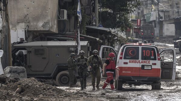 Soldados israelíes se preparan para controlar una ambulancia de la Media Luna Roja palestina a la entrada del campo de refugiados de Tulkarem, en Cisjordania, el 17 de enero de 2024  - Sputnik Mundo