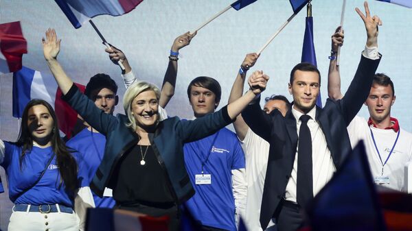 La líder del partido ultraderechista francés Agrupación Nacional, Marine Le Pen, y el principal candidato del partido para las próximas elecciones europeas, Jordan Bardella, asisten a un mitin político el 2 de junio de 2024 en París. - Sputnik Mundo