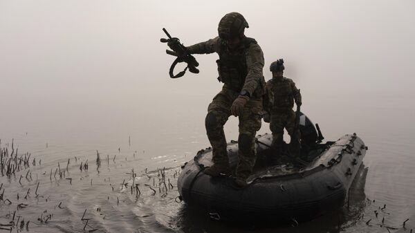 Un militar ucraniano salta del barco a la orilla del Dniéper en la línea del frente cerca de Jersón - Sputnik Mundo
