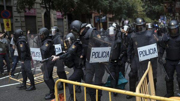 Policías antidisturbios españoles retiran las vallas que les han lanzado mientras intentan impedir que la gente llegue a un lugar de votación en Barcelona, España, el 1 de octubre de 2017  - Sputnik Mundo