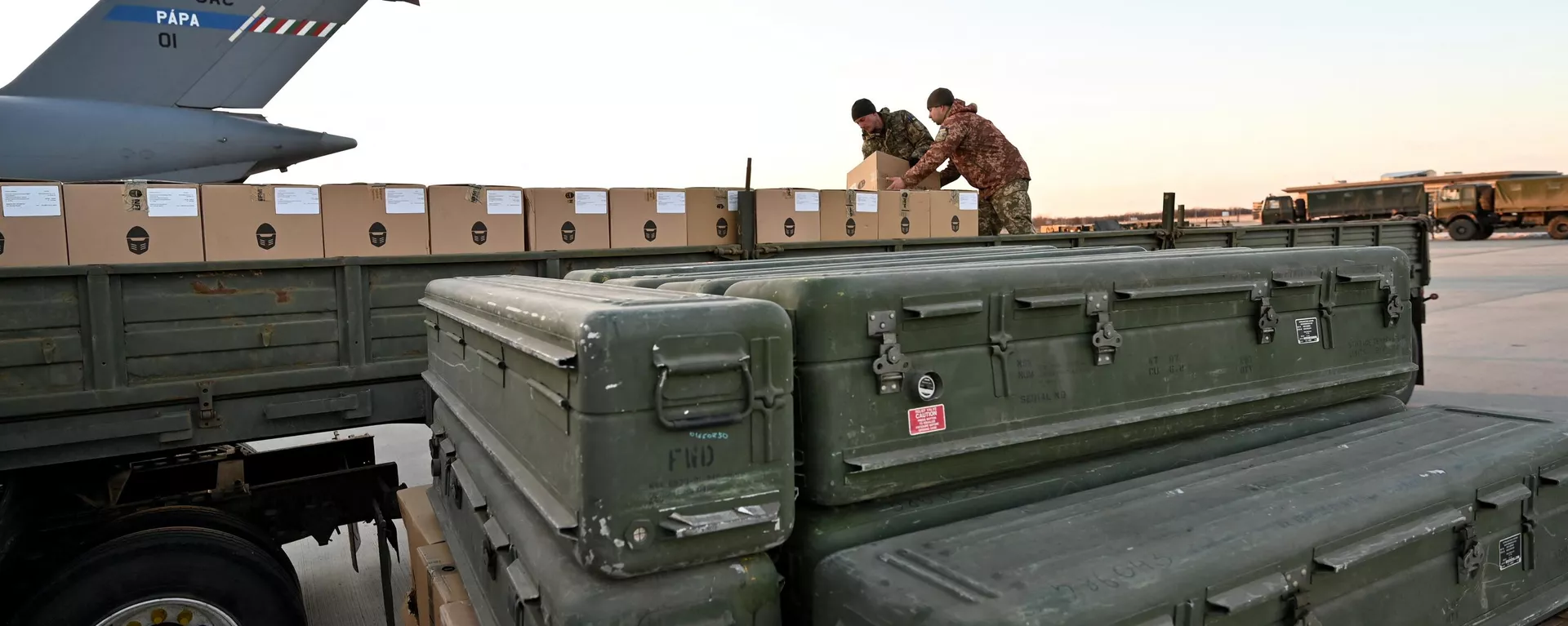 Militares ucranianos cargan un camión de plataforma con cajas mientras se apilan misiles estadounidenses FIM-92 Stinger (frente) y un sistema portátil de defensa antiaérea (Manpads) tras ser enviados al aeropuerto de Boryspil, en Kiev, el 13 de febrero de 2022 - Sputnik Mundo, 1920, 03.07.2024