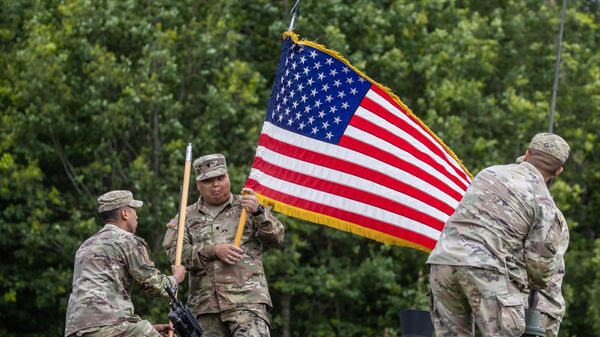 Soldados de las Fuerzas Armadas estadounidenses instalan la bandera nacional estadounidense en un vehículo militar antes de una rueda de prensa, Polonia, el 7 de julio de 2022 - Sputnik Mundo