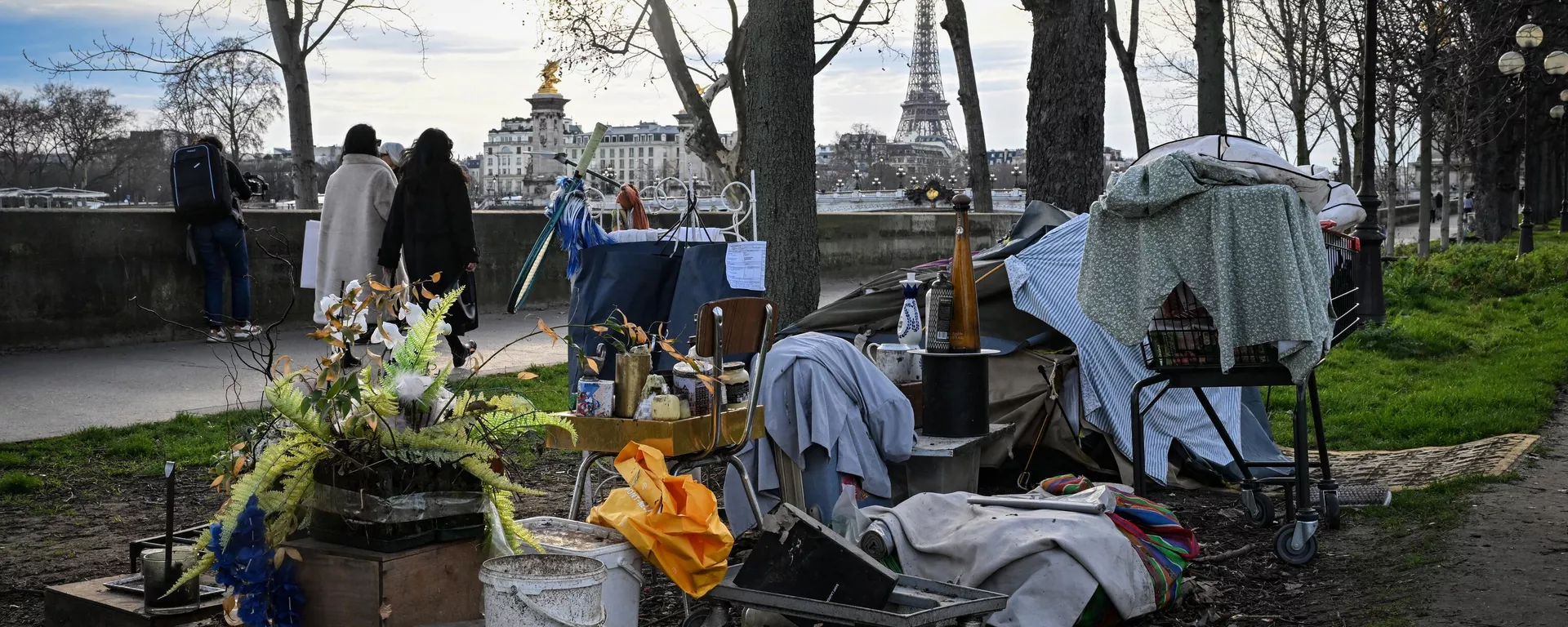 Peatones pasan al lado de un campamento de personas sin hogar cerca del río Sena con la Torre Eiffel al fondo, en el centro de París (Foto de Miguel MEDINA / AFP)
 - Sputnik Mundo, 1920, 12.07.2024