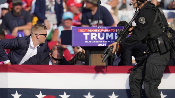 El candidato presidencial Donald Trump rodeado por agentes del Servicio Secreto tras el atentado en Pensilvania  - Sputnik Mundo