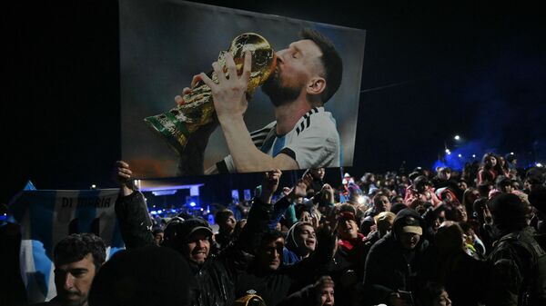 Un hombre sostiene una foto del delantero argentino Lionel Messi mientras espera la llegada de la selección argentina de fútbol en Ezeiza, Buenos Aires, Argentina, el 15 de julio de 2024.  - Sputnik Mundo