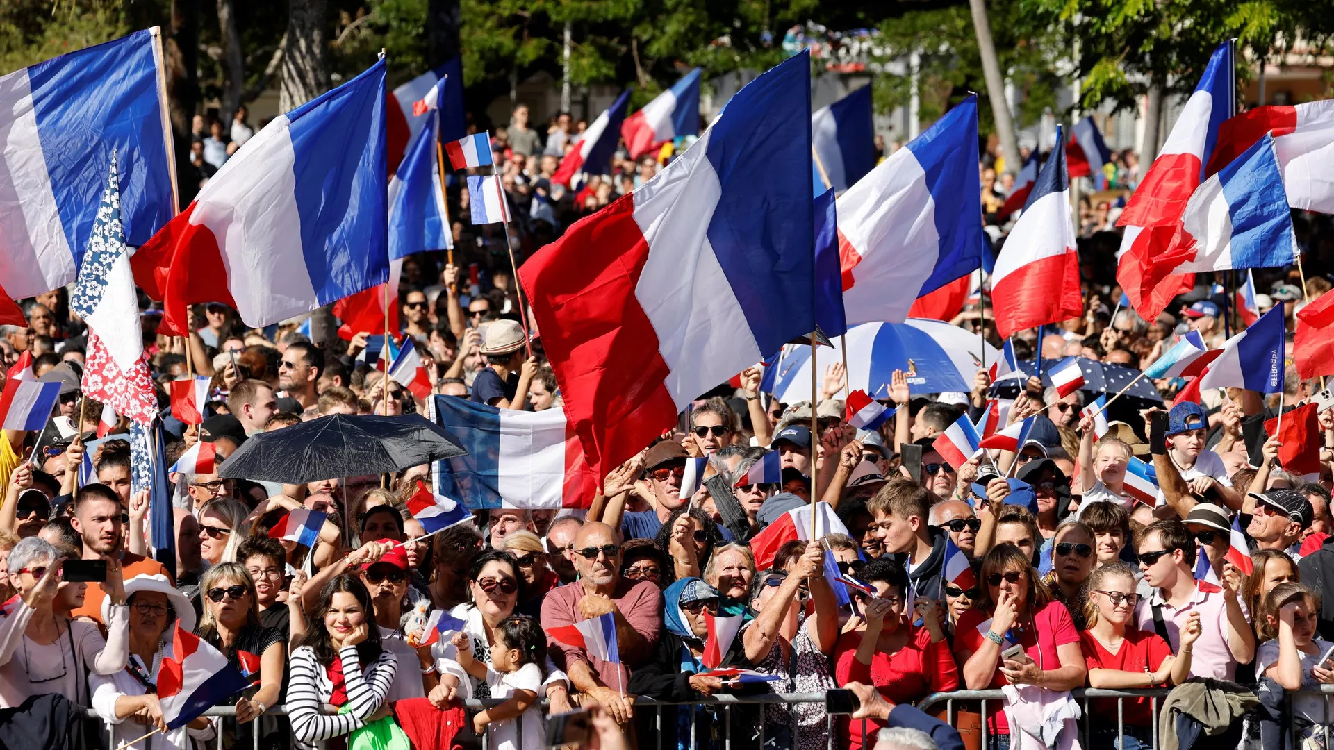 Una multitud ondea banderas francesas mientras el presidente Emmanuel Macron pronuncia su discurso en la Place des Cocotiers en Noumea el 26 de julio de 2023. - Sputnik Mundo, 1920, 20.07.2024