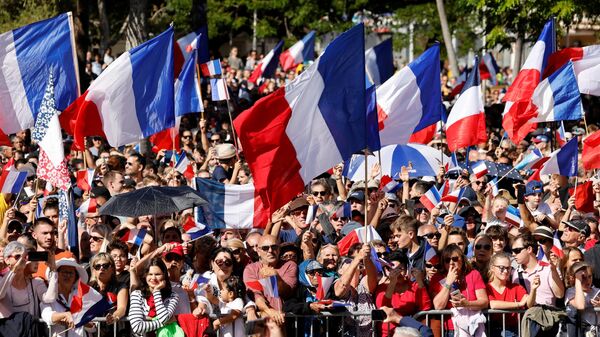 Una multitud ondea banderas francesas mientras el presidente Emmanuel Macron pronuncia su discurso en la Place des Cocotiers en Noumea el 26 de julio de 2023. - Sputnik Mundo