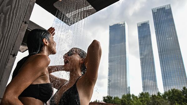 Chicas duchándose luego de nadar en la piscina Verano en el parque durante la ola de calor en Moscú, Rusia - Sputnik Mundo