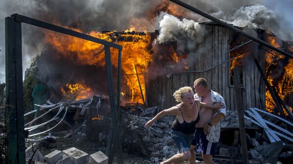 Vecinos del poblado de Lugánskaya, en Donbás, salvándose de un incendio provocado por bombardeos aéreos ucranianos (archivo) - Sputnik Mundo