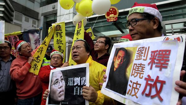 Manifestantes con los carteles del premio Nobel de la Paz Liu Xiaobo y a su mujer Liu Xia - Sputnik Mundo