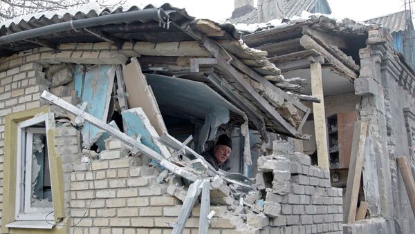A man removes debris inside his house, which according to locals was recently damaged by shelling, in Donetsk, eastern Ukraine - Sputnik Mundo
