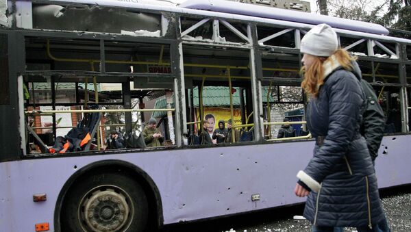 A woman walks past a damaged trolleybus in Donetsk, January 22, 2015. - Sputnik Mundo