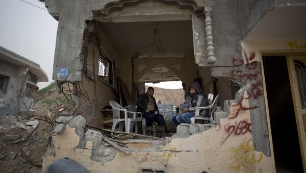Palestinians sit in a room of their war-damaged house in the Shijaiyah neighborhood of Gaza City, Tuesday, Jan. 6, 2015 - Sputnik Mundo