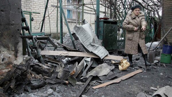 A woman looks at debris in front of a house, which according to locals, was recently damaged by shelling, in Donetsk, eastern Ukraine, January 17, 2015 - Sputnik Mundo