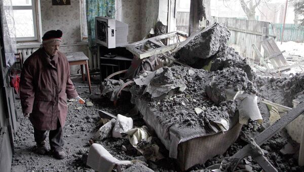 A woman surveys damage done to a house, which according to locals was recently damaged by shelling, in the suburbs of Donetsk January 30, 2015 - Sputnik Mundo