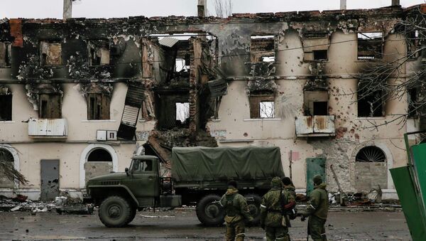 Members of the armed forces of the separatist self-proclaimed Donetsk People's Republic gather near a building destroyed during battles with the Ukrainian armed forces in Vuhlehirsk, Donetsk region, February 4, 2015 - Sputnik Mundo