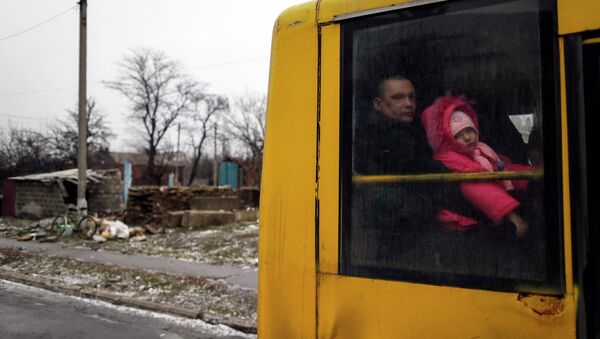 A man and a child look through a bus window before leaving as people flee the conflict in Debaltseve, eastern Ukraine, February 6, 2015. - Sputnik Mundo