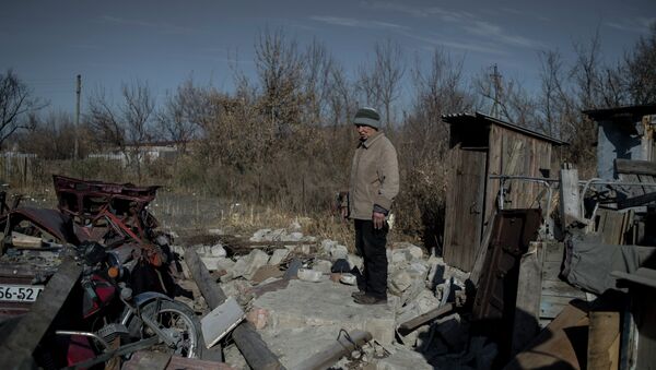 Местная жительница на месте своего разрушенного дома в поселке Новосветловка в Луганской области - Sputnik Mundo