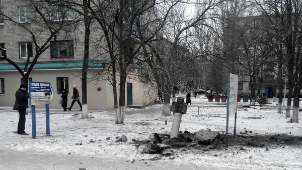 A resident passes by an unexploded rocket in a living area in Kramatorsk, Ukraine, Tuesday, Feb.10, 2015 - Sputnik Mundo