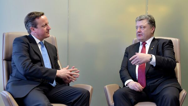 British Prime Minister David Cameron listens to Ukrainian President Petro Poroshenko (R) ahead of an European Union leaders summit in Brussels February 12, 2015 - Sputnik Mundo
