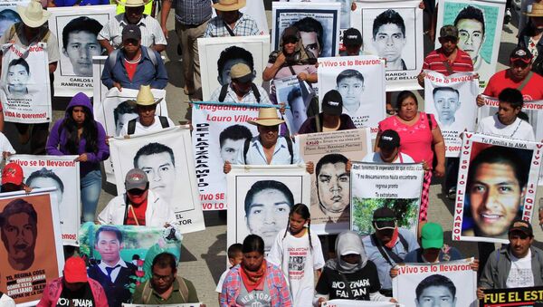 Familiares sostienen carteles de los 43 estudiantes desaparesidos en Guerrero, México - Sputnik Mundo
