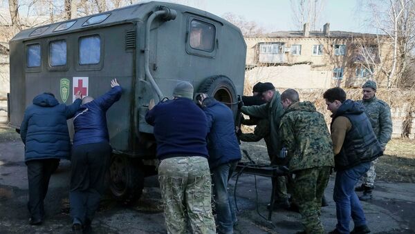 Members from a First Volunteer mobile hospital push a medical trailer in Artemivsk - Sputnik Mundo