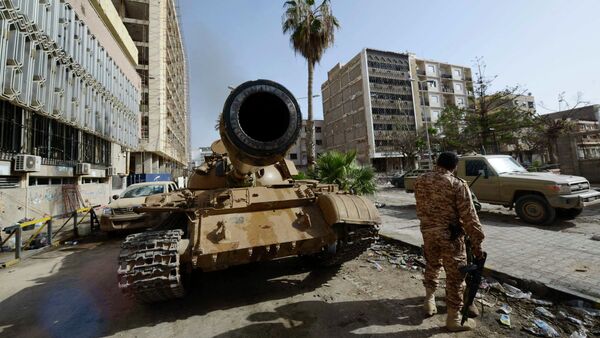 A member of the Libyan pro-government forces, backed by locals, stands near a tank outside the Central Bank, near Benghazi port, January 21, 2015 - Sputnik Mundo