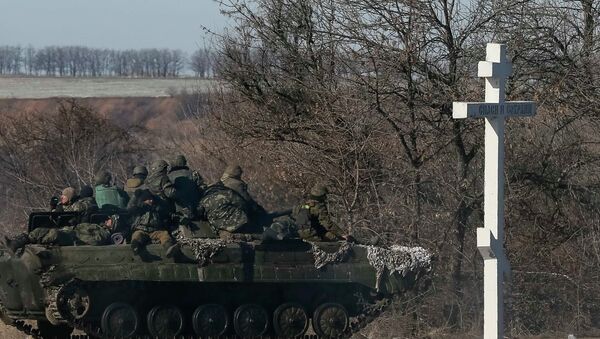 Ukrainian servicemen ride on a military vehicle as they leave an area around Debaltseve, February 18, 2015 - Sputnik Mundo