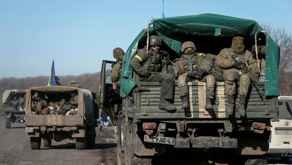Ukrainian servicemen ride on a military vehicle as they leave area around Debaltseve, eastern Ukraine near Artemivsk February 18, 2015 - Sputnik Mundo