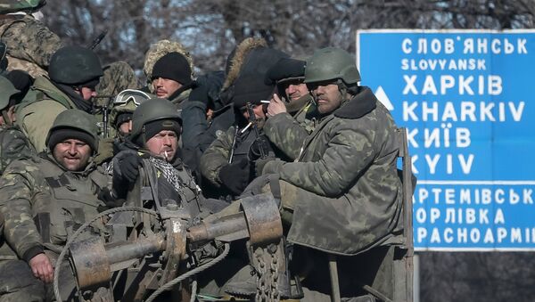 Ukrainian servicemen ride on a military vehicle as they leave the area around Debaltseve, February 18, 2015 - Sputnik Mundo
