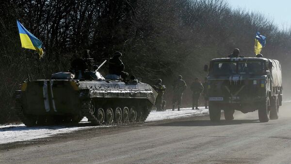 A Ukrainian APC stands on the side of the road as other military vehicles leave an area around Debaltseve, eastern Ukraine near Artemivsk, February 18, 2015. - Sputnik Mundo