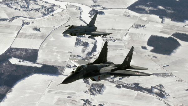 A Polish Air Force MIG-29 fighter (front) and an Italian Air Force Eurofighter Typhoon fighter patrol over the Baltics during a NATO air policing mission from Zokniai air base near Siauliai February 10, 2015. - Sputnik Mundo