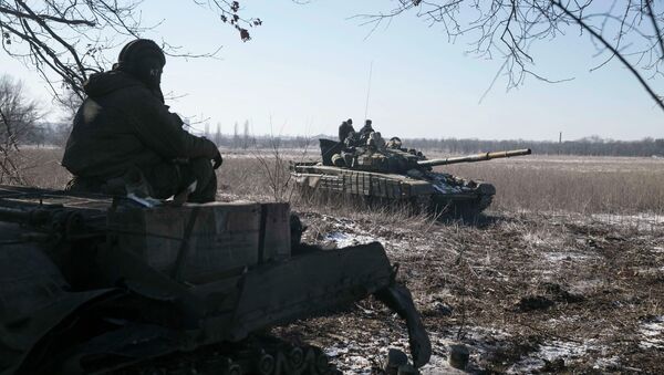 A tank crew member with the separatist self-proclaimed Donetsk People's Republic Army sits on top of a tank at a checkpoint on the road from the town of Vuhlehirsk to Debaltseve February 18, 2015 - Sputnik Mundo