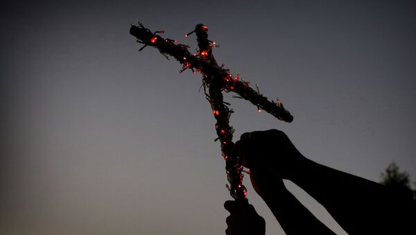 Iraqi Christians, who fled the violence in the city of Mosul, decorate a cross with lights in commemoration of the Elevation of the Holy Cross festival on September 14, 2014, in Arbil - Sputnik Mundo