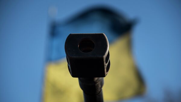 Una bandera ucraniana se ve detrás de un cañón - Sputnik Mundo