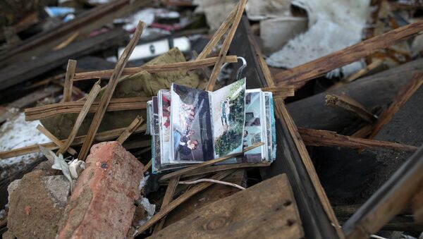 Album de fotos de la familia se ve en las ruinas de una casa en un barrio cerca de Donetsk - Sputnik Mundo