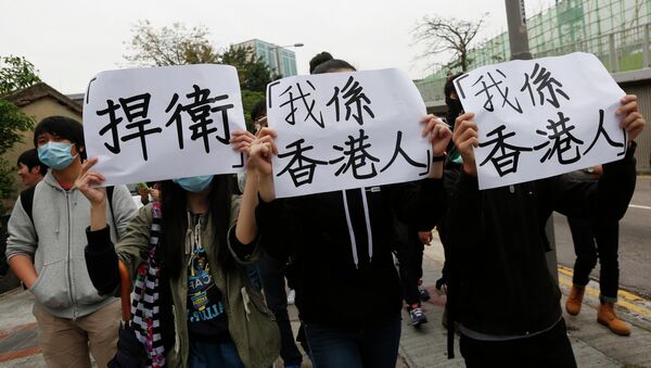 Protesters hold signs reading, Defend and I am from Hong Kong as they march during a demonstration against mainland traders, at Yuen Long in Hong Kong March 1, 2015 - Sputnik Mundo