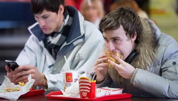 Un hombre come una hamburguesa de McDonald's - Sputnik Mundo