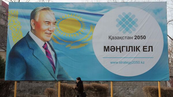 A woman walks past a poster depicting Kazakhstan's President Nursultan Nazarbayev in Almaty February 16, 2015 - Sputnik Mundo