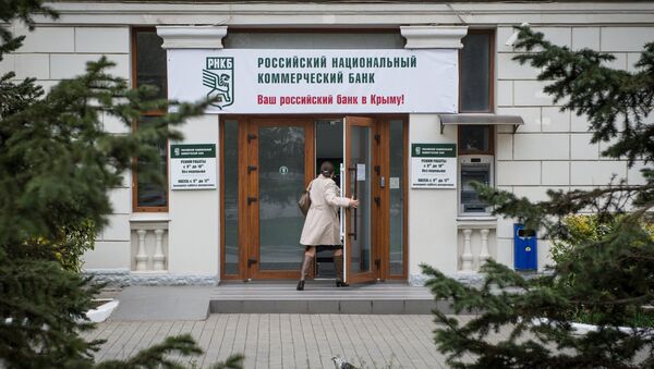 Женщина входит в здание Российского национального коммерческого банка в городе Севастополе - Sputnik Mundo