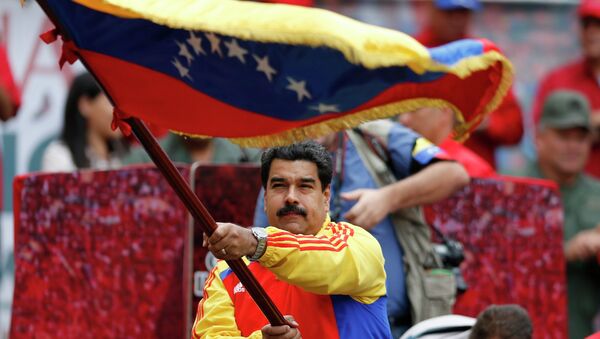 Nicolas Maduro con la bandera de Venezuela - Sputnik Mundo