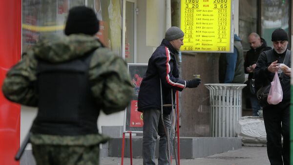 Hombre pide en una calle en Kiev - Sputnik Mundo