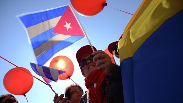 People carry Cuba's (L) and Venezuela's (R) flags during a traditional May Day rally of Russian communist party in central Moscow on May 1, 2014 - Sputnik Mundo