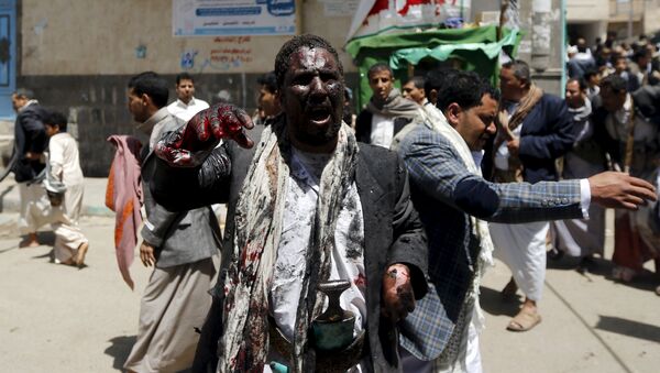 An injured man appeals for help as he waits for an ambulance outside a mosque which was attacked by a suicide bomber in Sanaa March 20, 2015. - Sputnik Mundo