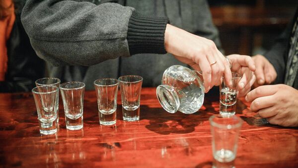 Una persona llenando vasos de alcohol (imagen referencial) - Sputnik Mundo