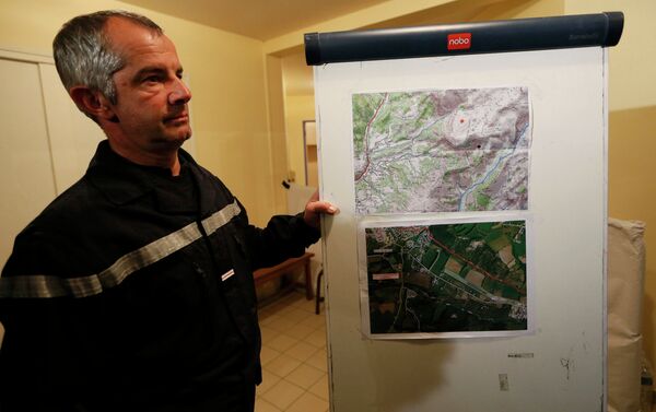 Un bombero francés se encuentra en la escuela secundaria cerca de mapas que muestran la zona en el que Airbus A320 se estrelló en los Alpes franceses - Sputnik Mundo